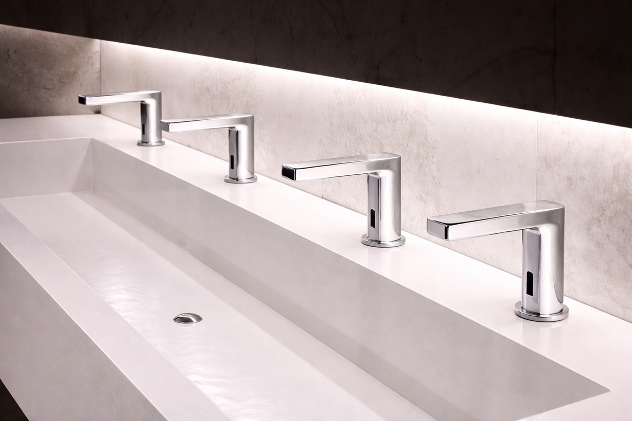High traffic institutional public restroom with durable sensor faucets